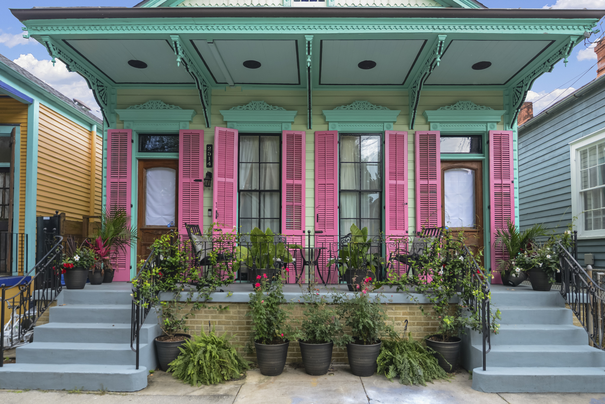 Colorful historic Creole cottage with pink shutters in a New Orleans neighborhood